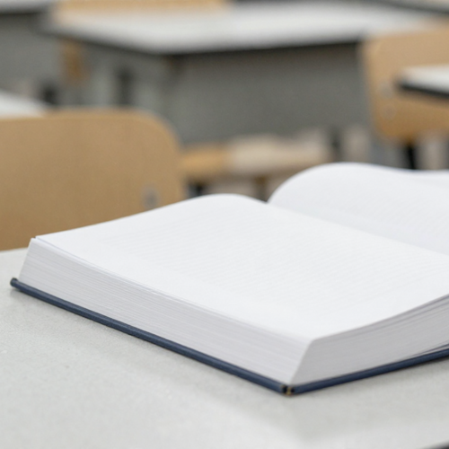 Ein aufgeschlagenes Buch in einem Klassenraum. Alle Seiten sind leer.